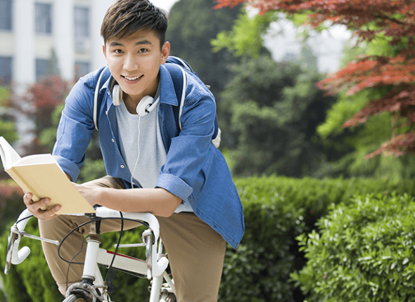 Un élève qui sourit sur un vélo avant son tutorat avec La 2e Classe