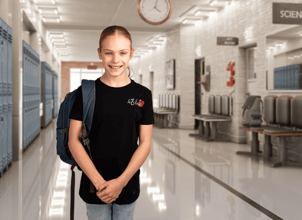 Une jeune fille, équipée de son sac à dos, se tient dans un corridor lumineux de l'école. Son regard déterminé et son attitude prête pour la journée reflètent la résilience et l'enthousiasme des étudiants de La 2e Classe prêts à apprendre et à réussir.