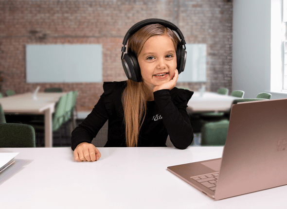 Une petite fille suit attentivement un cours en ligne proposé par La 2e Classe. Devant son ordinateur dans un environnement domestique, elle incarne la concentration et la détermination des jeunes élèves engagés dans l'apprentissage à distance.