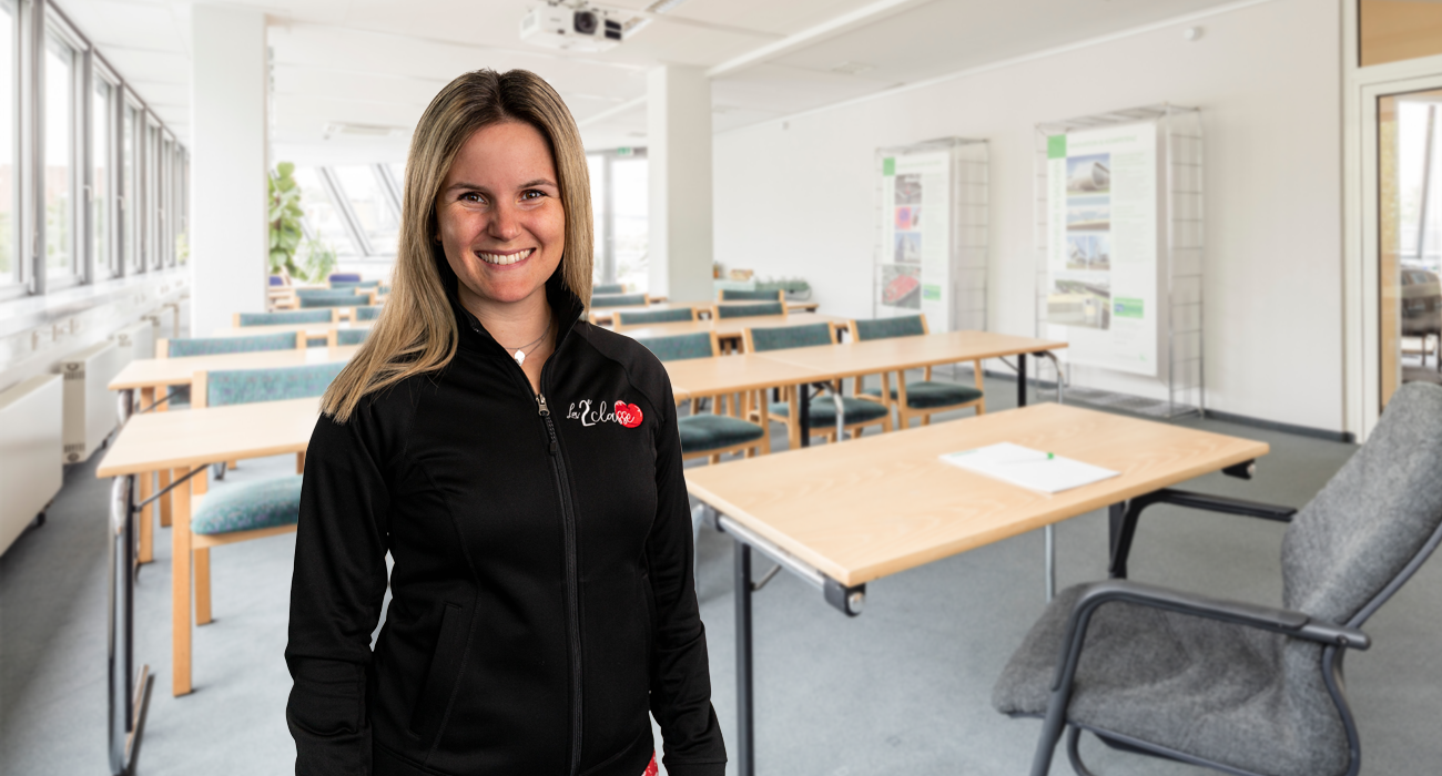 Une enseignante enthousiaste dans une salle de classe à La 2e Classe, inspirant ses élèves avec son dévouement et son engagement envers l'excellence éducative.