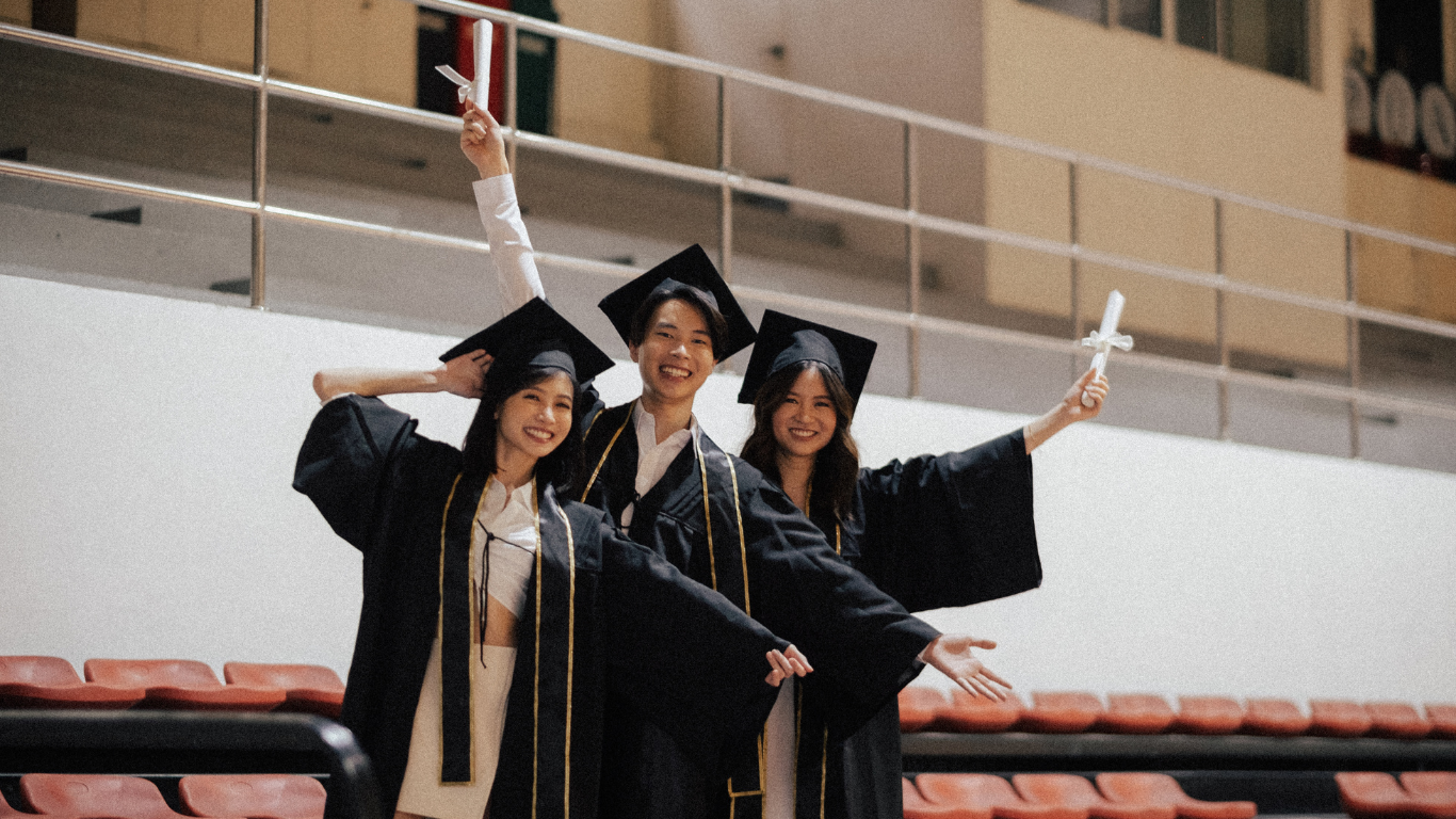 Trois étudiants en toge et mortier célèbrent leur diplôme au secondaire en ligne avec leurs certificats.